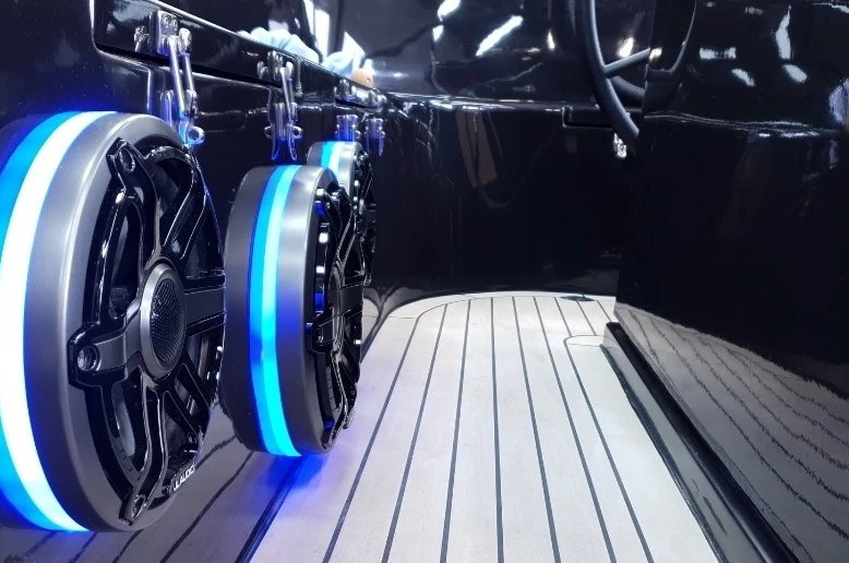 JL Audio speaker met blauwe LED-ring boven teakvloer
