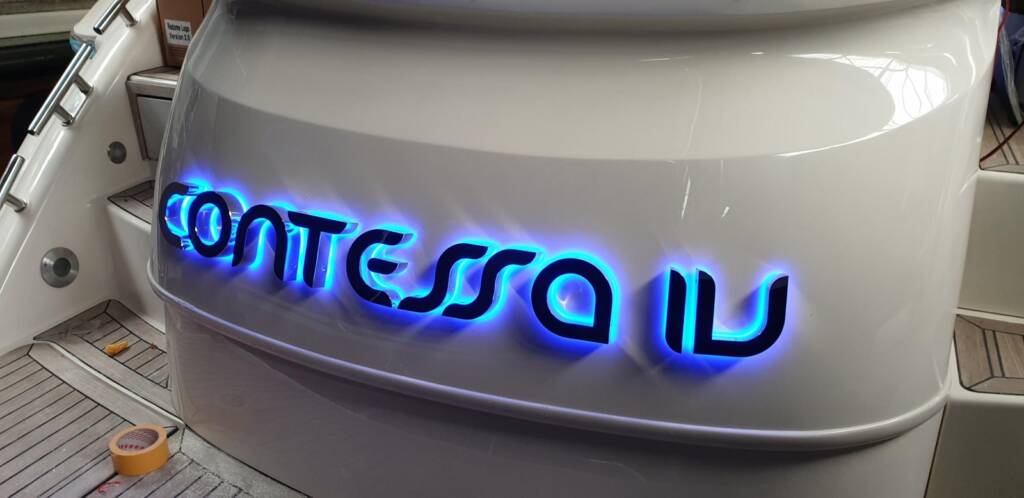 Verlichte bootnaam in losse letters op de spiegel
